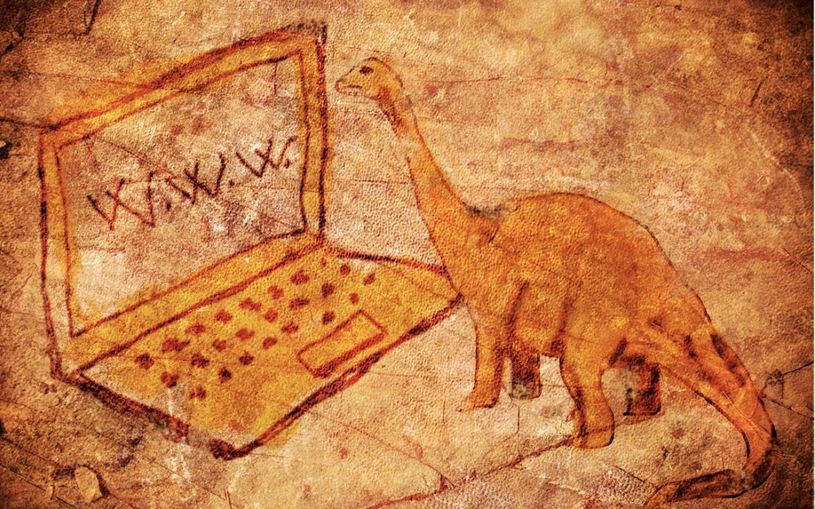 cave drawing of dinosaur staring at laptop screen