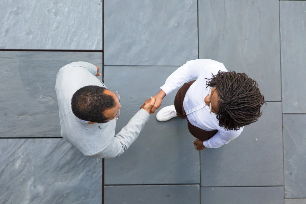 A man and woman shaking hands after a deal